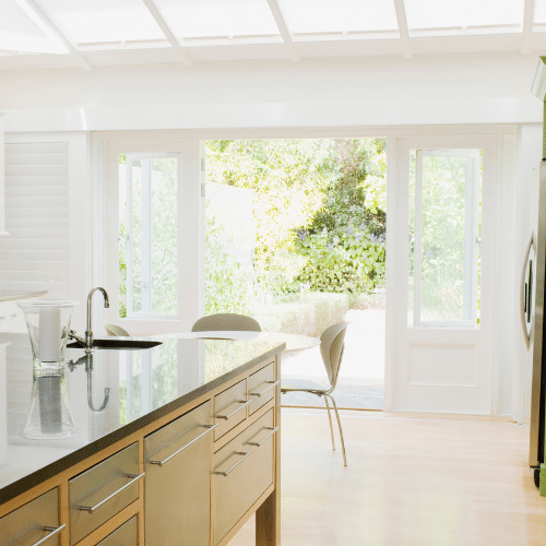 White counter on a kitchen island inside an all-white interior with skylights